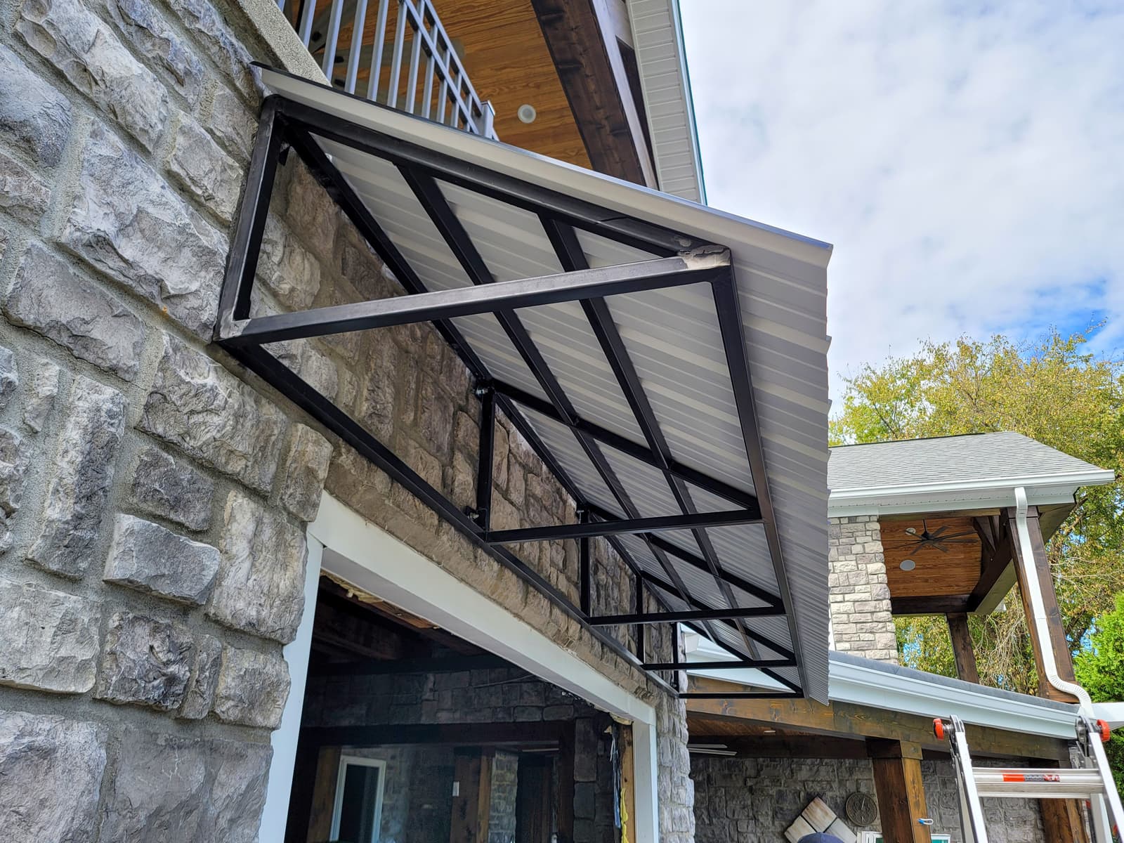 Custom welded metal awning frame and wall-support components.
