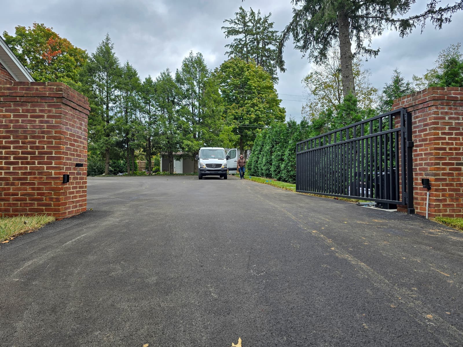 Wide custom driveway gate fabricated for a long vehicle opening.