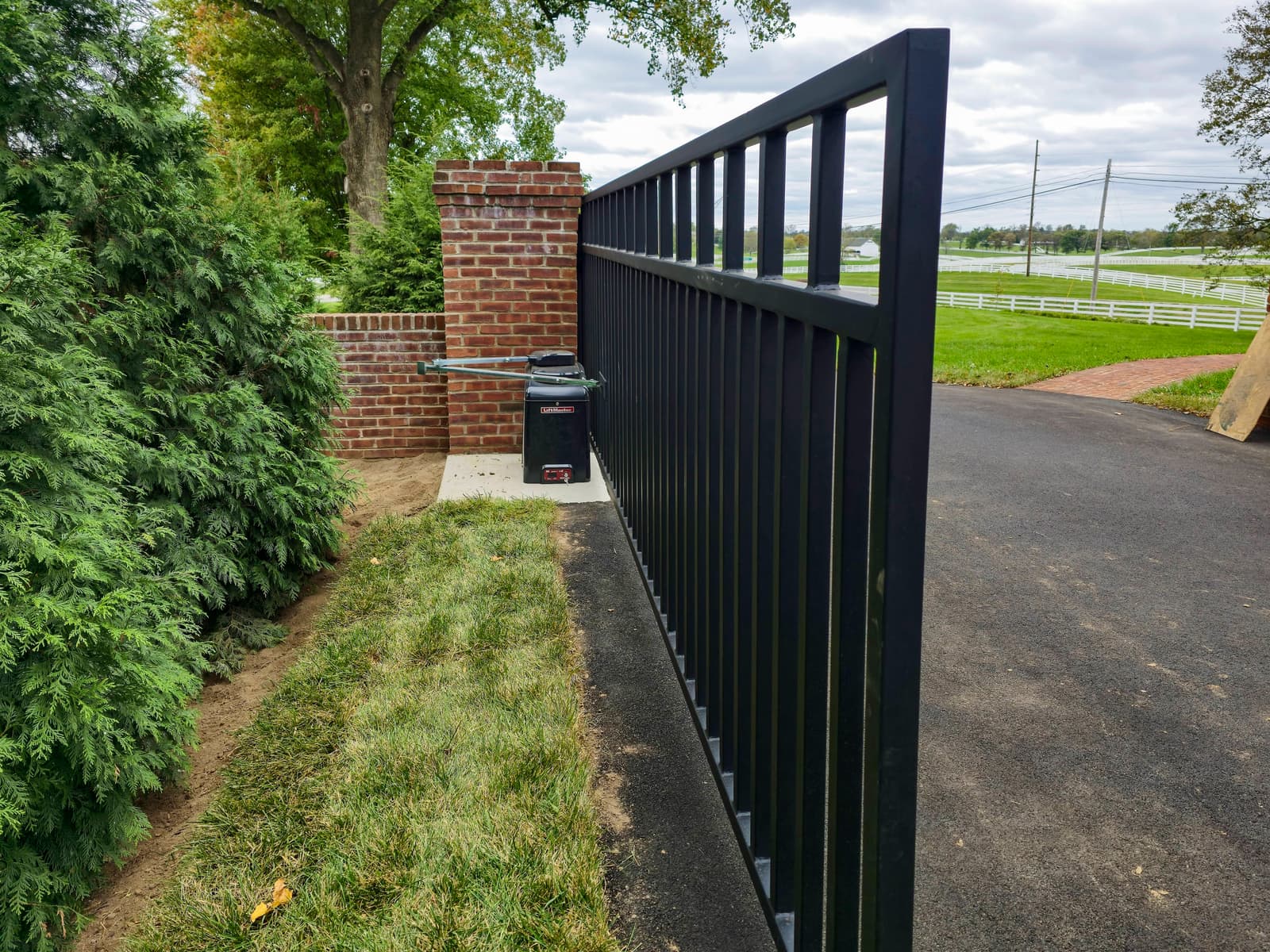 Metal driveway gate installation with welded frame and picket details.