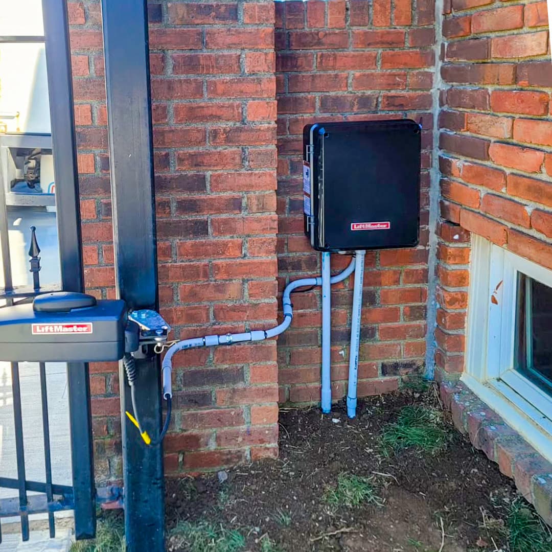 LiftMaster operator and control box beside a brick gate pier