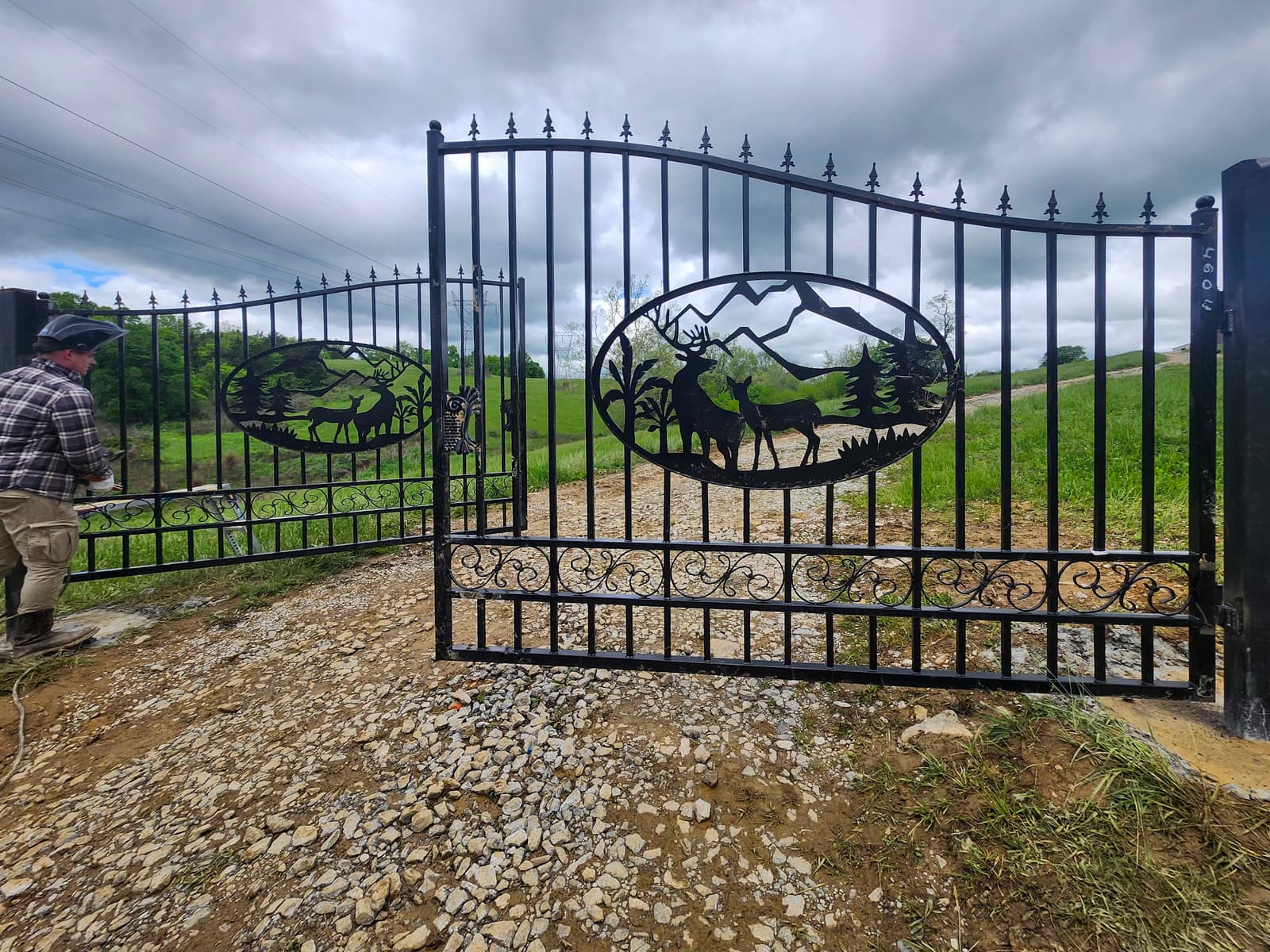 Decorative metal driveway gate with custom welded panel details.