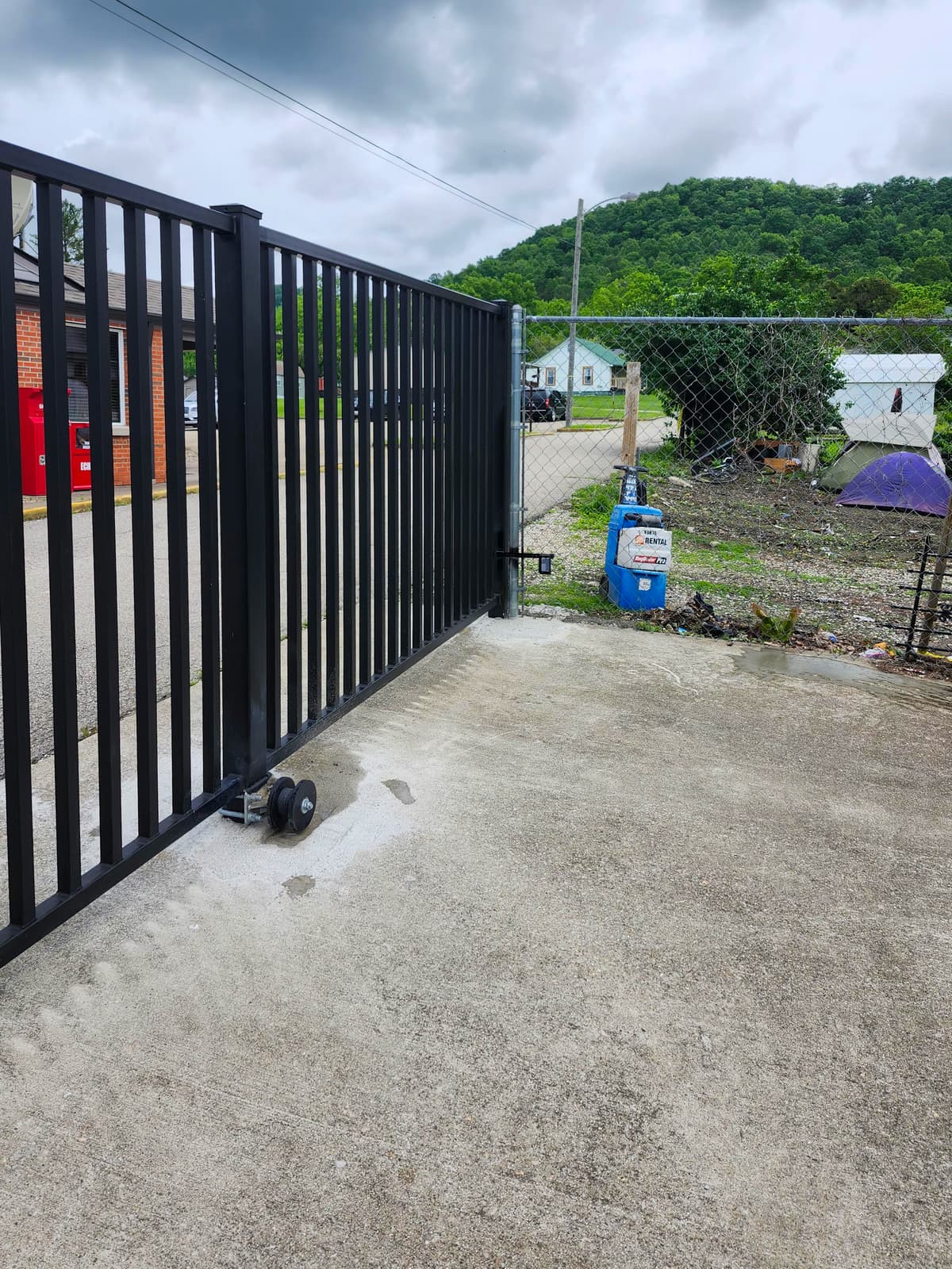 Sliding metal gate track and frame installation detail.