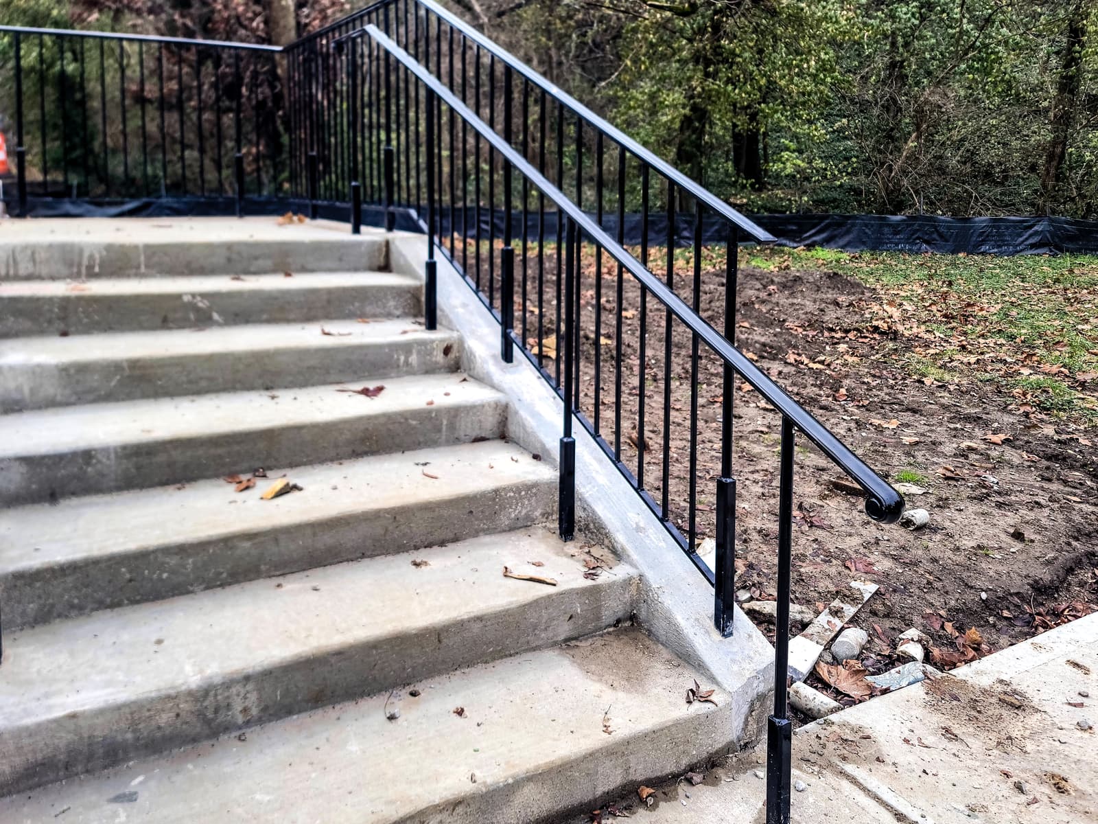 Commercial staircase railing and fence-line metalwork.
