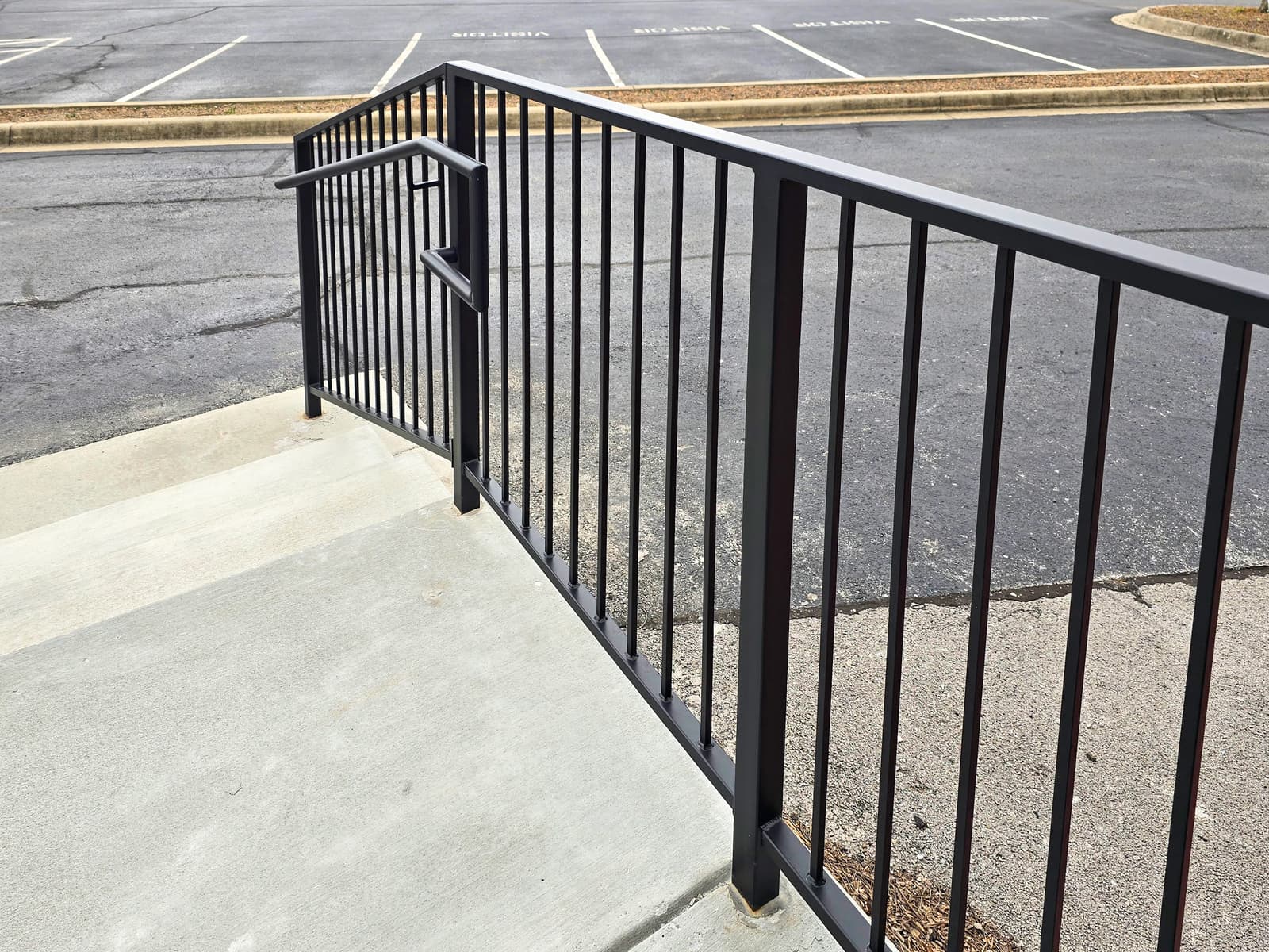 Commercial property safety railing with black welded guardrails.