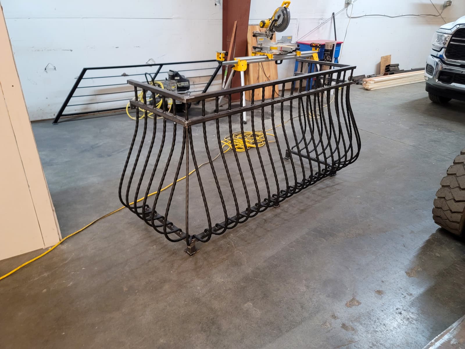 Deck staircase and balcony railing with black welded metal sections.