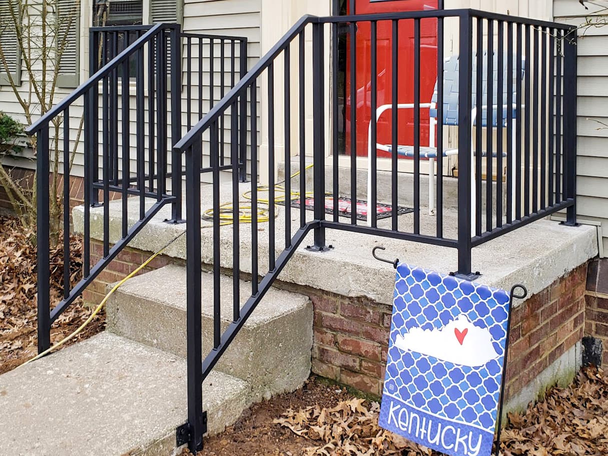 Black metal entry handrail installed on brick steps in Lexington, KY.