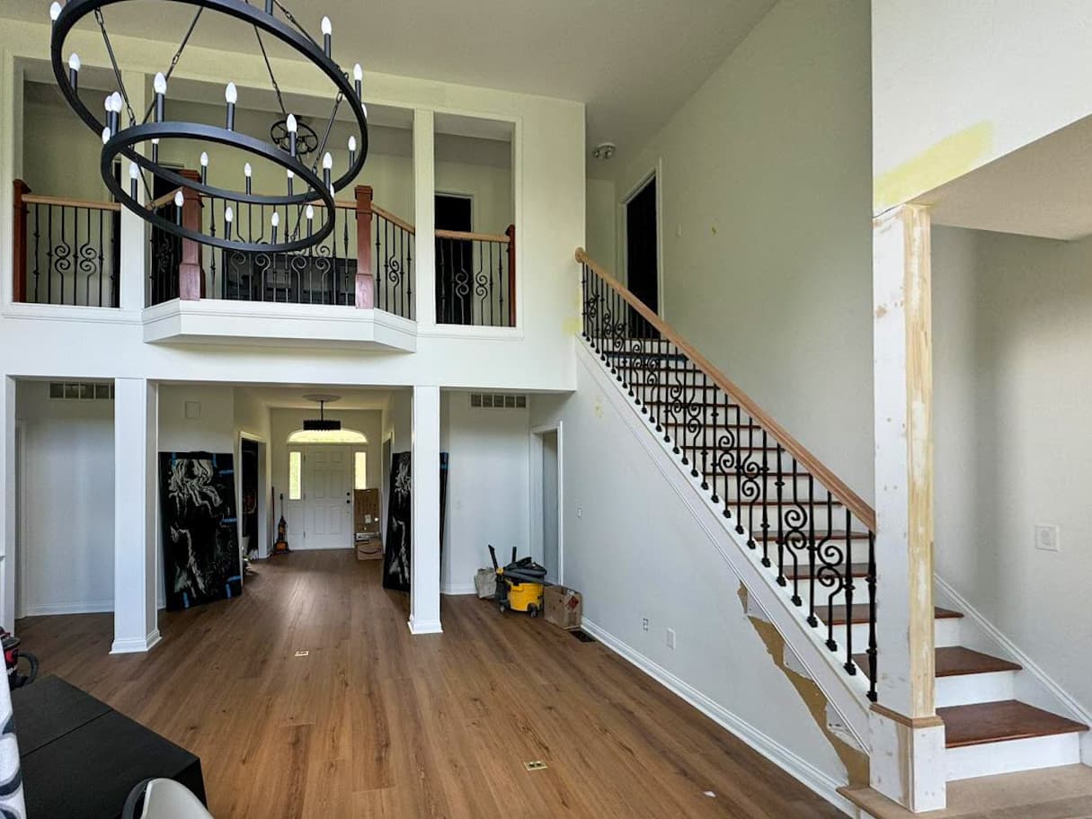 Ornamental iron stair railing and matching upstairs balcony railings inside a home.